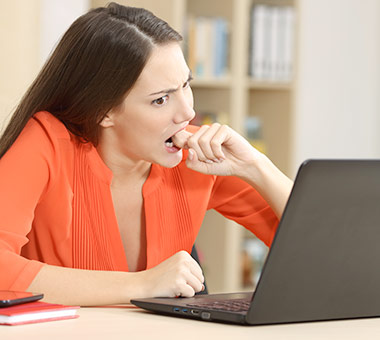 Frustrated and worried woman looking at laptop.